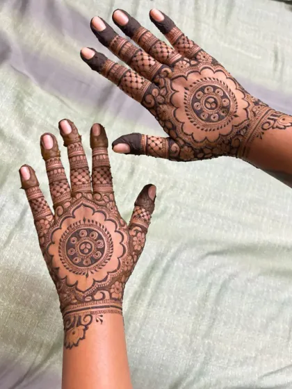 A different style of party mehndi with a central mandala and detailed fingers.