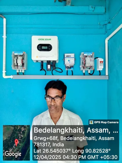 A happy customer in Bedelangkhaiti, Assam, stands before his newly installed 3kW on-grid system. The bright blue wall makes our white inverter pop!