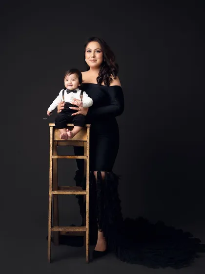 A full-length portrait of a glamorous mother and her dapper son.