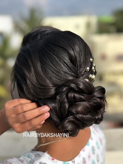 A client adjusting her beautiful textured low bun, a candid and elegant shot.