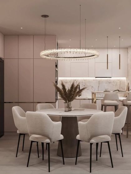 A close-up of the dining area, featuring a modern round table and comfortable upholstered chairs under a stunning crystal ring chandelier. This setup is ideal for both family meals and formal dinners.