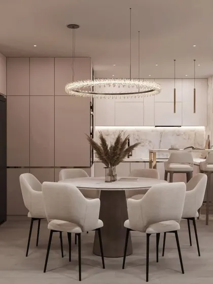 A close-up of the dining area, featuring a modern round table and comfortable upholstered chairs under a stunning crystal ring chandelier. This setup is ideal for both family meals and formal dinners.