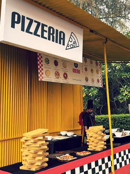 A bold and graphic "Pizzeria" setup with a yellow and checkerboard theme. This eye-catching stall is perfect for large, high-energy events and carnivals.
