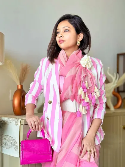 The full look with the pink structured bag. The monochromatic pink palette is broken up by the white stripes, creating a balanced and eye-catching outfit.