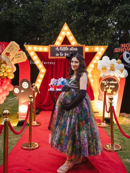 The beautiful mom-to-be, the star of the show, posing on the red carpet. I love creating themed decor that not only looks great but also makes the guests of honor feel truly special.