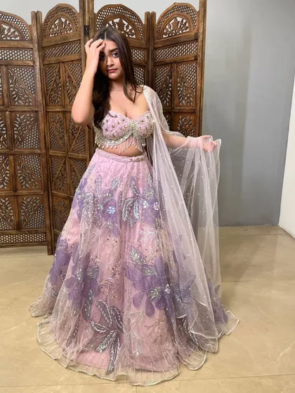 The cape-style dupatta adds a contemporary touch to this beautifully embroidered lehenga.