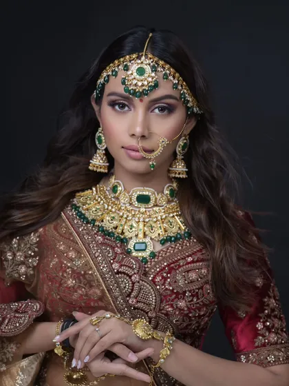 A full-frame shot of a bride in a traditional red and green lehenga. This is a classic look that is always in demand.