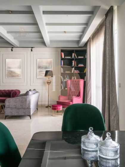 A wide shot of the featured Gurgaon residence, showing the open-plan living and dining area. The coffered ceiling, eclectic furniture, and curated lighting come together to create a lush and statement-making home.