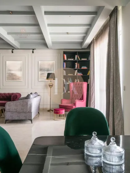 A wide shot of the featured Gurgaon residence, showing the open-plan living and dining area. The coffered ceiling, eclectic furniture, and curated lighting come together to create a lush and statement-making home.