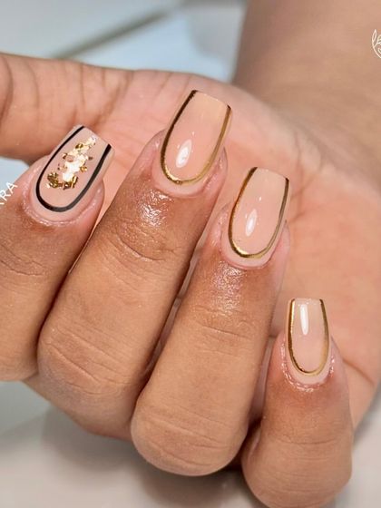 Glamour in simplicity. An acrylic overlay with clean gold chrome borders and an accent nail with black lines and gold foil.