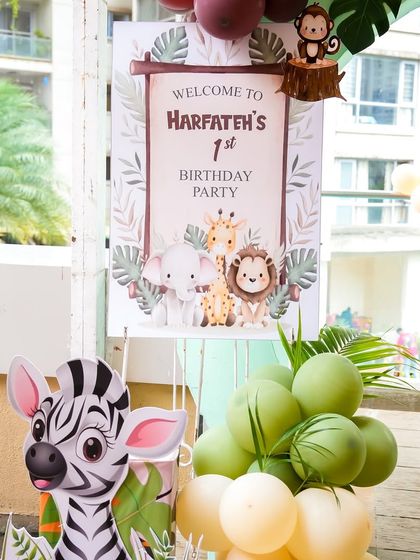 The welcome sign for the first birthday party, featuring a gentle, illustrated safari animal theme.