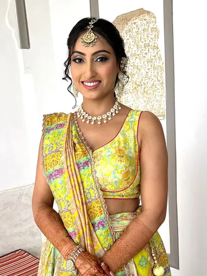 Another angle of this stunning Mehendi look. The makeup is subtle, with a focus on glowing skin and defined eyes, letting her natural radiance shine through.
