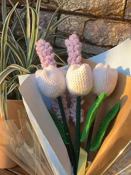 A close-up of the wrapped tulip and lavender bouquet. The clear cellophane allows the beautiful handmade flowers to be the star of the show.