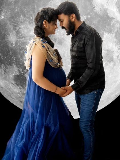 A magical and creative portrait of a couple silhouetted against a giant moon, holding hands and connecting.