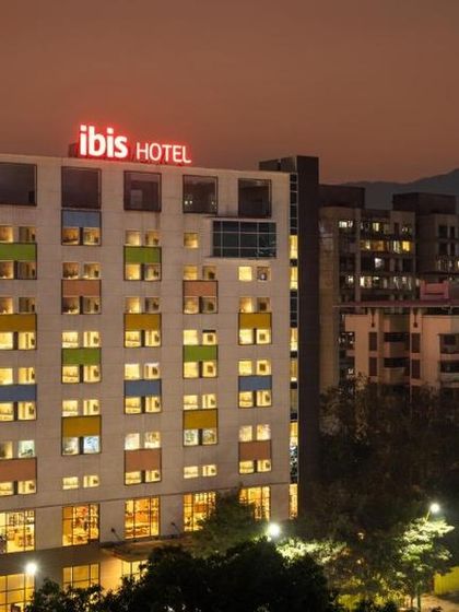 The IBIS Hotel in Thane illuminated at night. The building's facade incorporates playful pops of color, giving it a unique and welcoming identity within the urban landscape.