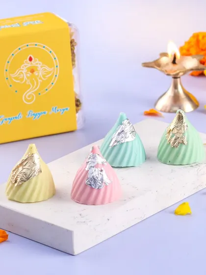 Our delicate chocolate modaks are filled with deliciousness and topped with silver leaf. They are a beautiful addition to any Ganpati celebration.