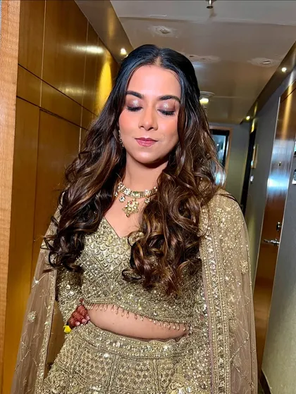 A close-up of Disha's Sangeet look, featuring sparkling gold eyeshadow and soft curls.
