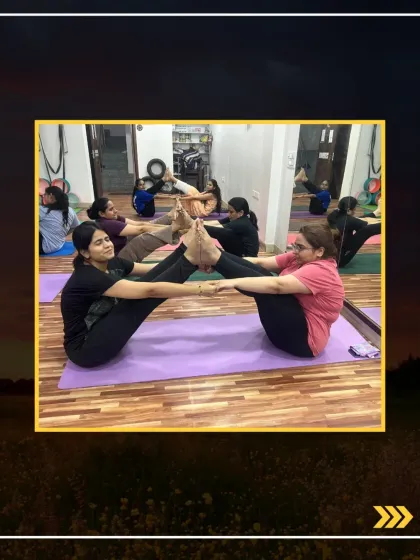 Two students holding a strong partner boat pose, demonstrating balance and synchronized effort.