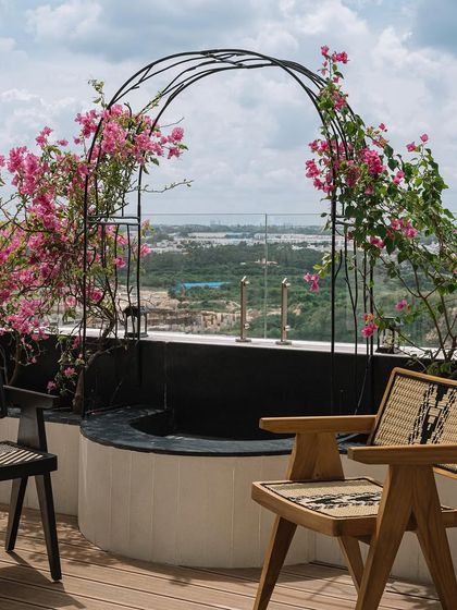 A beautiful seating nook on the outdoor deck, framed by a bougainvillea-covered arch, offering a picturesque spot to enjoy the view.