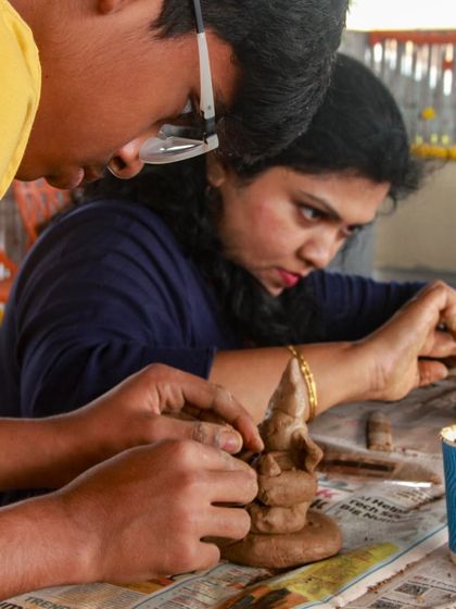 A couple carefully sculpts their Ganesha idol. It's a meditative and rewarding process, connecting art, spirituality, and sustainability.
