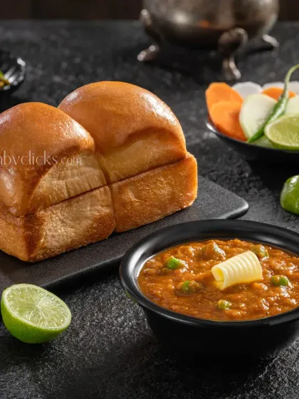 A classic serving of Pav Bhaji for Jain Sweets, with a dollop of butter melting on top.