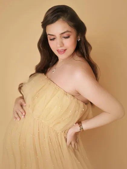A close-up of this gorgeous mom-to-be in her beautiful yellow gown. Her expression is so soft and loving as she looks down towards her bump.