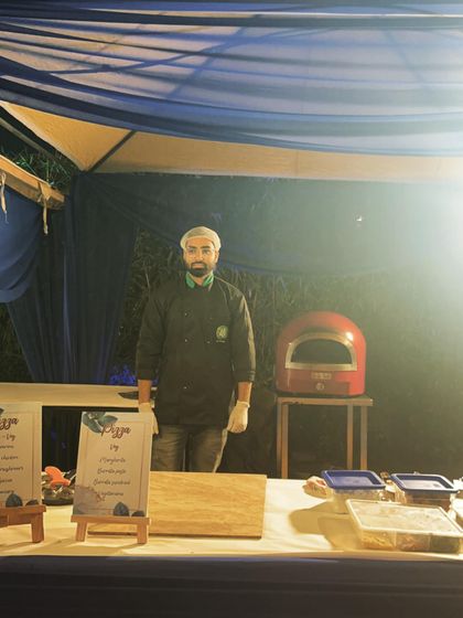 A simple and elegant setup for an evening party. The dark blue canopy and warm lighting create a sophisticated ambiance for my live pizza station.