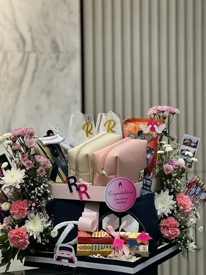 The full view of the football and fur-baby wedding hamper, complete with fresh flowers and polaroids of the couple. It’s a gift that truly tells their story.