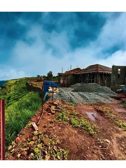 The construction site in Vagamon, with building materials ready for use against the backdrop of the hills. This image captures the raw, early stages of a project where the vision begins to take physical form.
