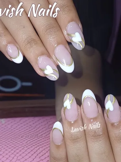 A romantic design with a white French tip, delicate gold swirls, and a sweet white heart accent.