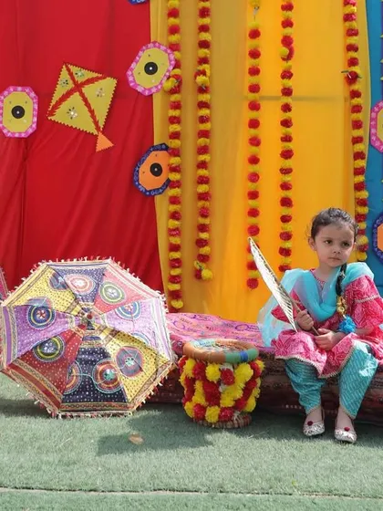 A quiet moment amidst the vibrant Baisakhi decorations. Our outdoor area is transformed with kites, flowers, and colorful fabrics to celebrate the harvest festival.