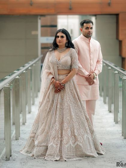 A classic, full-length portrait of the couple on a modern walkway. Their pose is elegant and timeless.