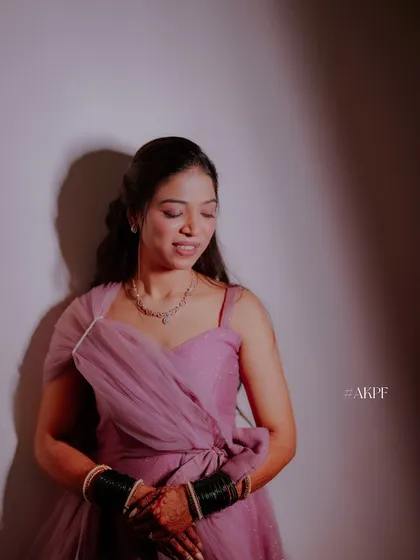 A quiet moment during the Sangeet. The lighting highlights the soft shimmer in her makeup, perfect for an evening event.