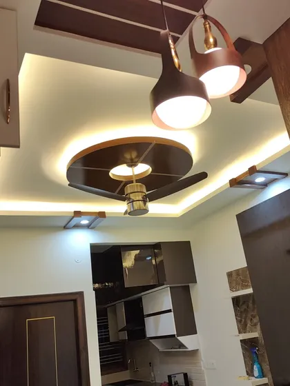 Our wood polishing services extend to architectural elements too. This living room features a false ceiling with wooden panels and a fan base that we polished to a high sheen, adding warmth and sophistication to the overall interior design.