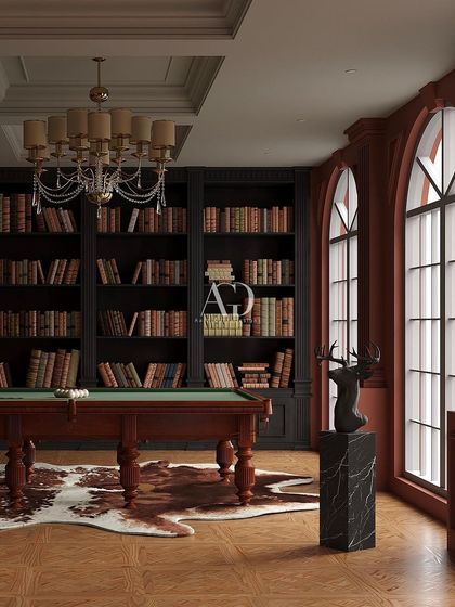 This playful yet Victorian ambiance was created with deep red walls and a classic billiard table. The room doubles as a game room and library, with dark wood bookshelves and large arched windows creating a sophisticated and fun environment.