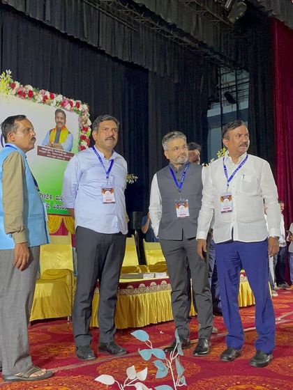 Standing on stage with fellow organizers of the MY SEVA TRUST event. Teamwork is essential for such large-scale initiatives.