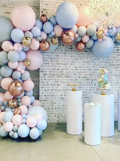 A beautiful and versatile balloon garland in pastel pink, blue, and rose gold chrome. This type of organic balloon arch is perfect for creating a soft, celebratory atmosphere and works well as a backdrop for a cake table or photo booth.