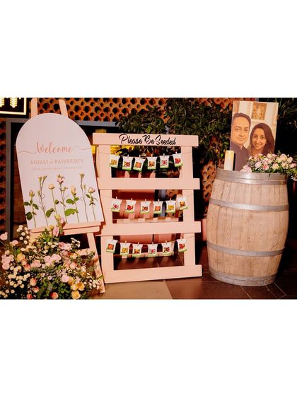 A clear view of the welcome and seating station, showcasing the personalized details like the couple's photo and the coordinated floral arrangements.