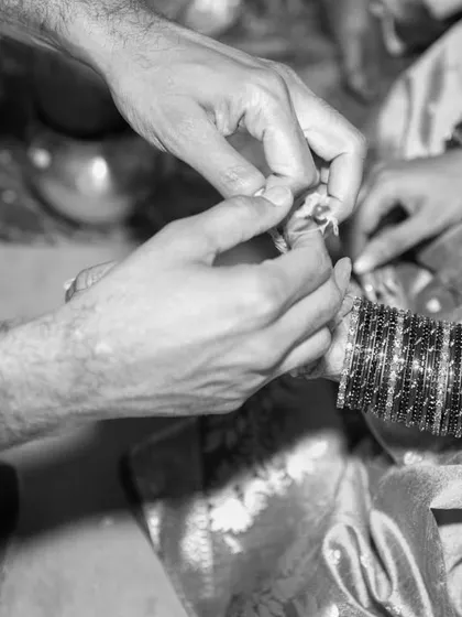 Some moments are so profound they feel timeless. This black and white photograph captures the intimate detail of a ring exchange during a wedding ceremony. By focusing on the hands and the ritual, we preserve the quiet, emotional core of the commitment being made.