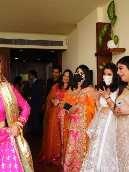 The bride's grand entrance to show her final look to her bridesmaids. Their happy and excited reactions are a beautiful, candid part of the wedding story.