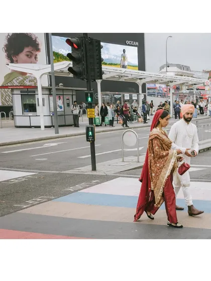 A newly married Shaan and Shubham cross a street in London, their traditional attire a striking contrast to the urban landscape. This is the kind of unique, adventurous storytelling we love.