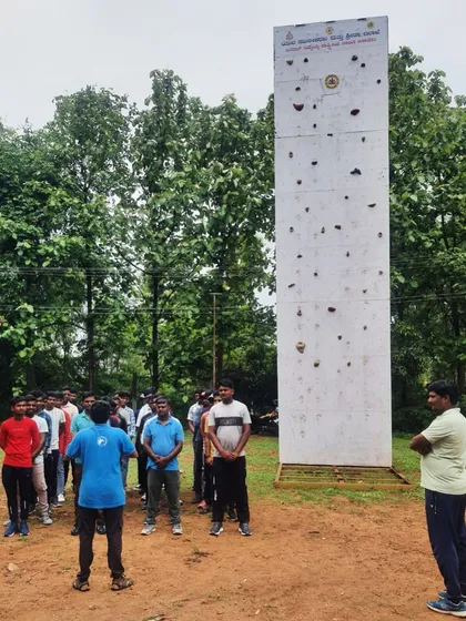 A group of young men listens to instructions before starting their session on the climbing wall in Ramanagara.