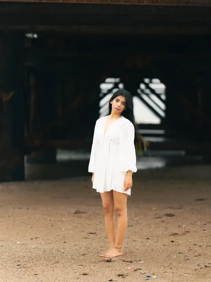 A wide shot that creates a feeling of smallness and solitude against the massive, dark structure of the pier.