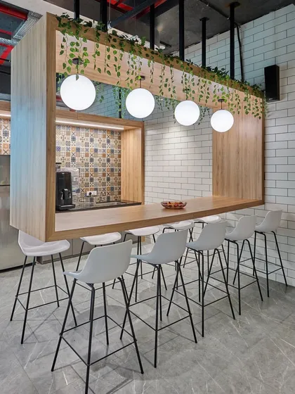 This pantry features a "table with a twist". A large wooden frame hangs from the ceiling, defining the bar area and incorporating lighting and greenery.