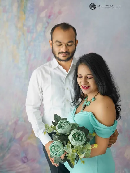 A sweet and gentle portrait. The soft colors of the gown and flowers, combined with the couple's relaxed pose, create a feeling of pure contentment.