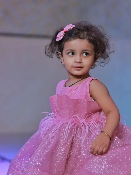 A sweet portrait of a little girl with curly hair and a pink bow, looking thoughtfully to the side. I love capturing these quiet, beautiful moments.