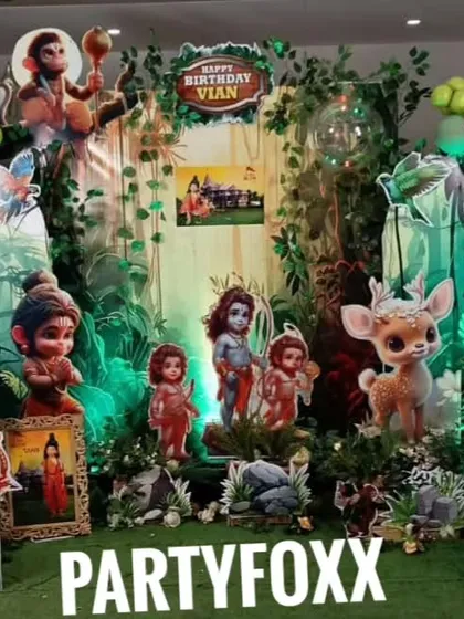 A unique Ramayan theme for Vian's birthday party. This intricate setup features character cutouts from the epic, set against a lush, forest-like backdrop with green lighting.