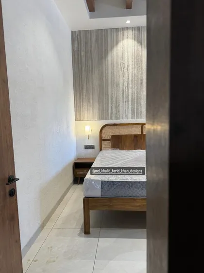 A peek into one of the hotel rooms, showing a mid-century bed with a cane and wood headboard.