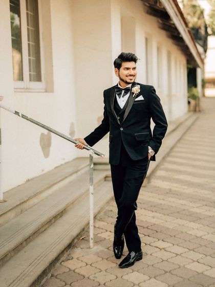 A smiling portrait of the groom. This candid shot captures his happiness and dapper style on his wedding day.