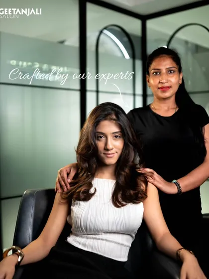 Crafted by our experts. A client poses with her stylist, showing the personal connection and expert care that goes into every service.